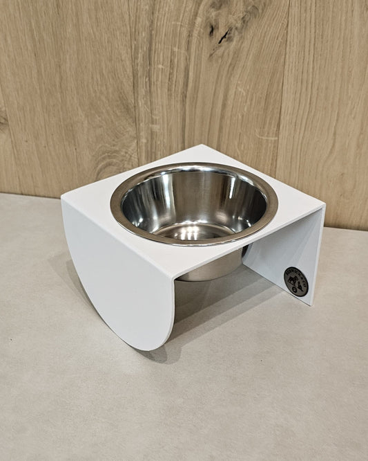 White elevated pet feeder with a metal bowl on a neutral background